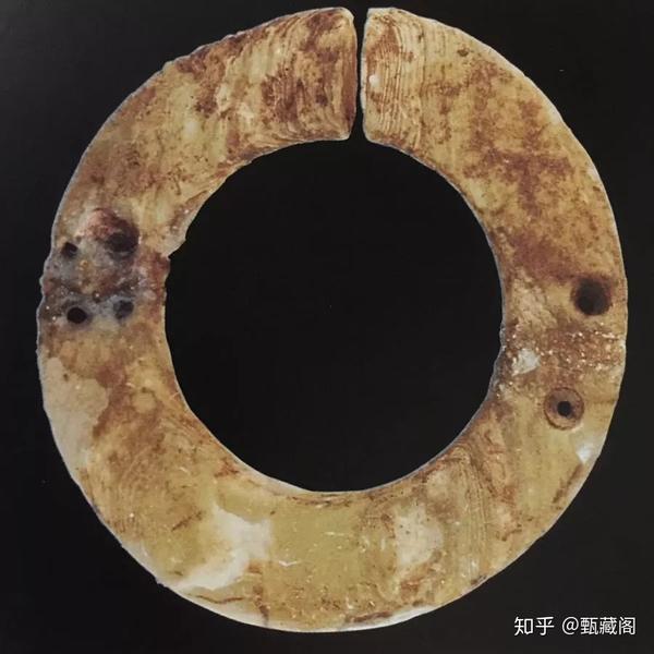 重庆市巫山县大溪遗址42号墓出土 玉璜中部断裂,裂纹两侧各有一个修复