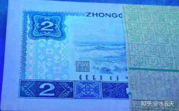 在荧光灯下,2元绿钻发出绿色荧光的"田"字图案,看上去像一粒粒钻石,它