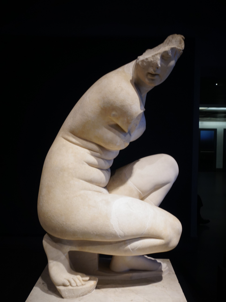 这件雕像采用半蹲姿势,双手已经失去,是残缺的样子,头也残缺了一半