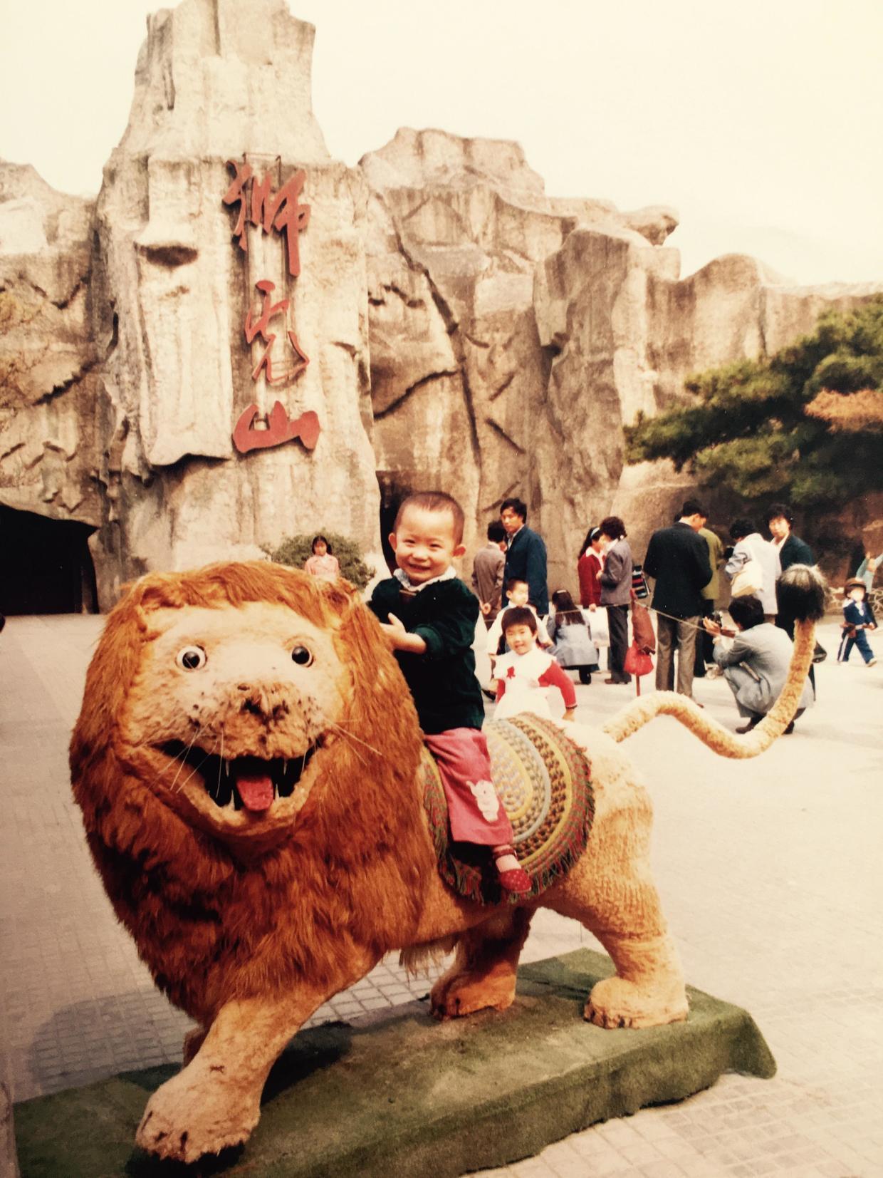 第一次去動物園的記憶,是塵封在一張老照片上,我坐在獅虎山前的一個大