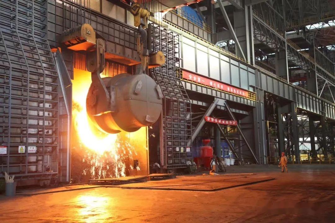炼钢厂转炉车间,工人们的脸庞在熊熊炉火映照下显得精神焕发,红光满面