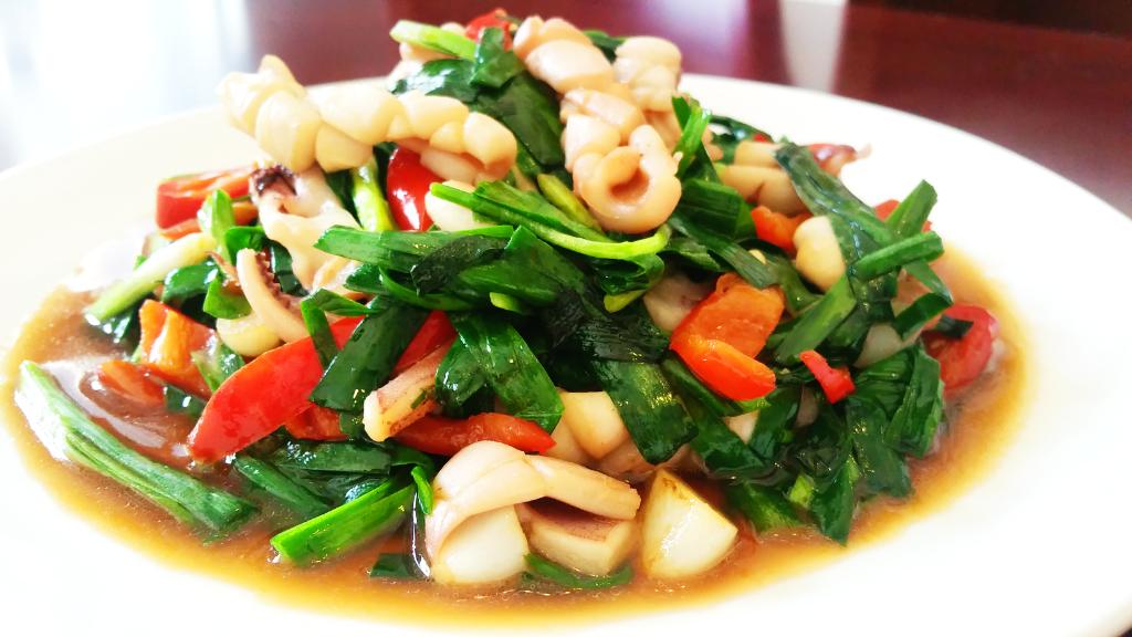 加姜蒜爆香,将鱿鱼,红椒倒入后加少量料酒,生抽,糖,盐翻炒均匀,5,韭菜