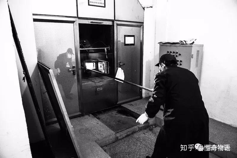 殡仪馆的一名工作人员打开停尸房里的一个隔间,查看逝者的遗体生老病