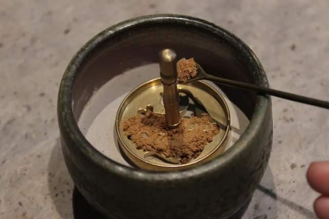 隔火熏香① 松香灰用火筷搅拌香灰,使其松动,有助于炭的燃烧;② 夹