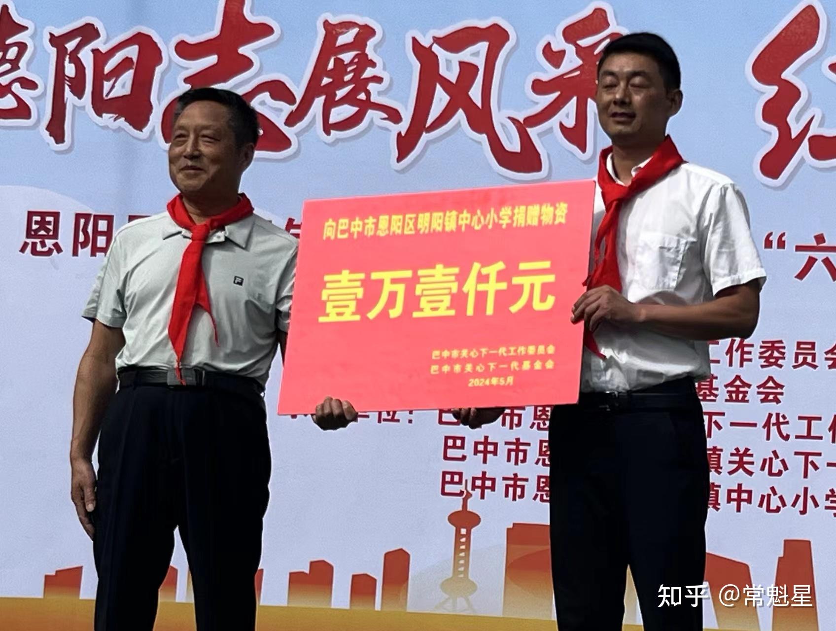 巴中市关工委常务副主任谷继礼(左),向恩阳区明阳中心小学捐赠物资