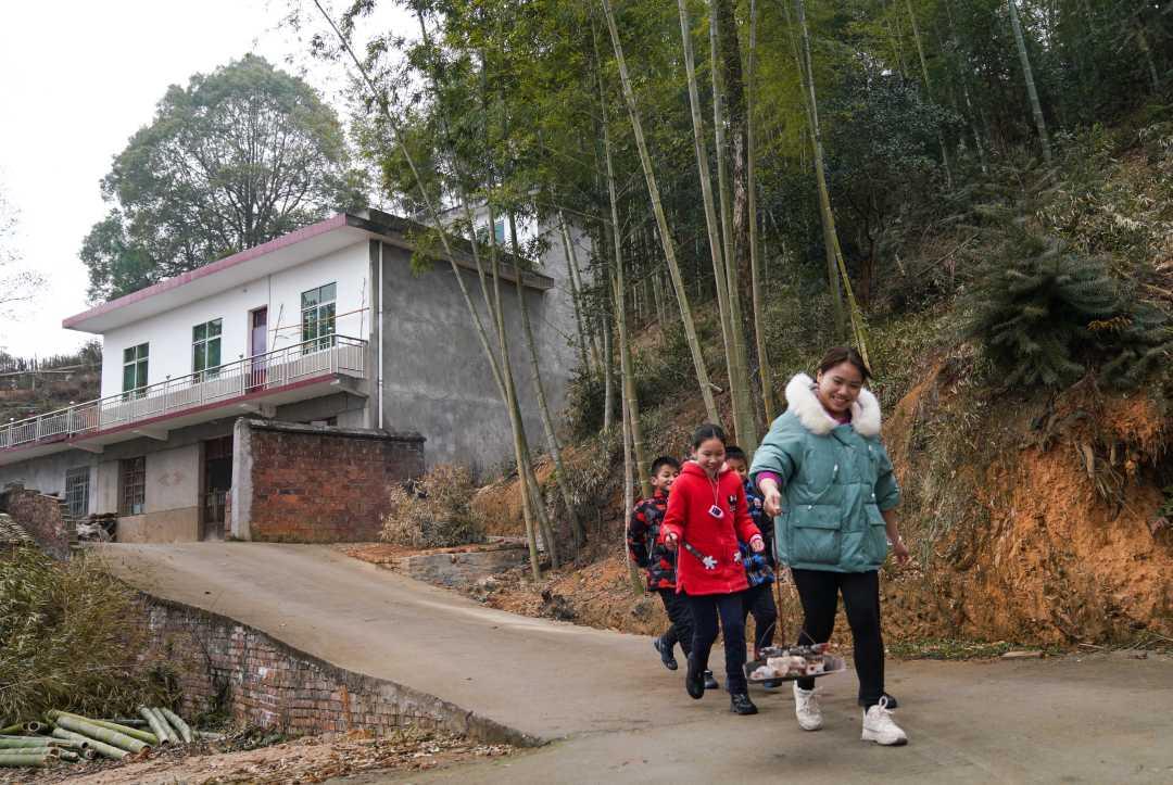 2月3日,竹亭鎮中心小學4年級學生李玉春在看大家烤肉.