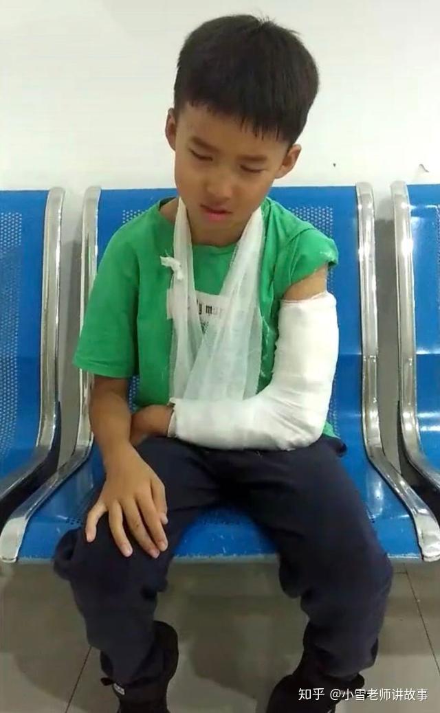 一个孩子打着石膏坐在医院的长椅哭泣,他为什么哭?是手臂很痛吗?