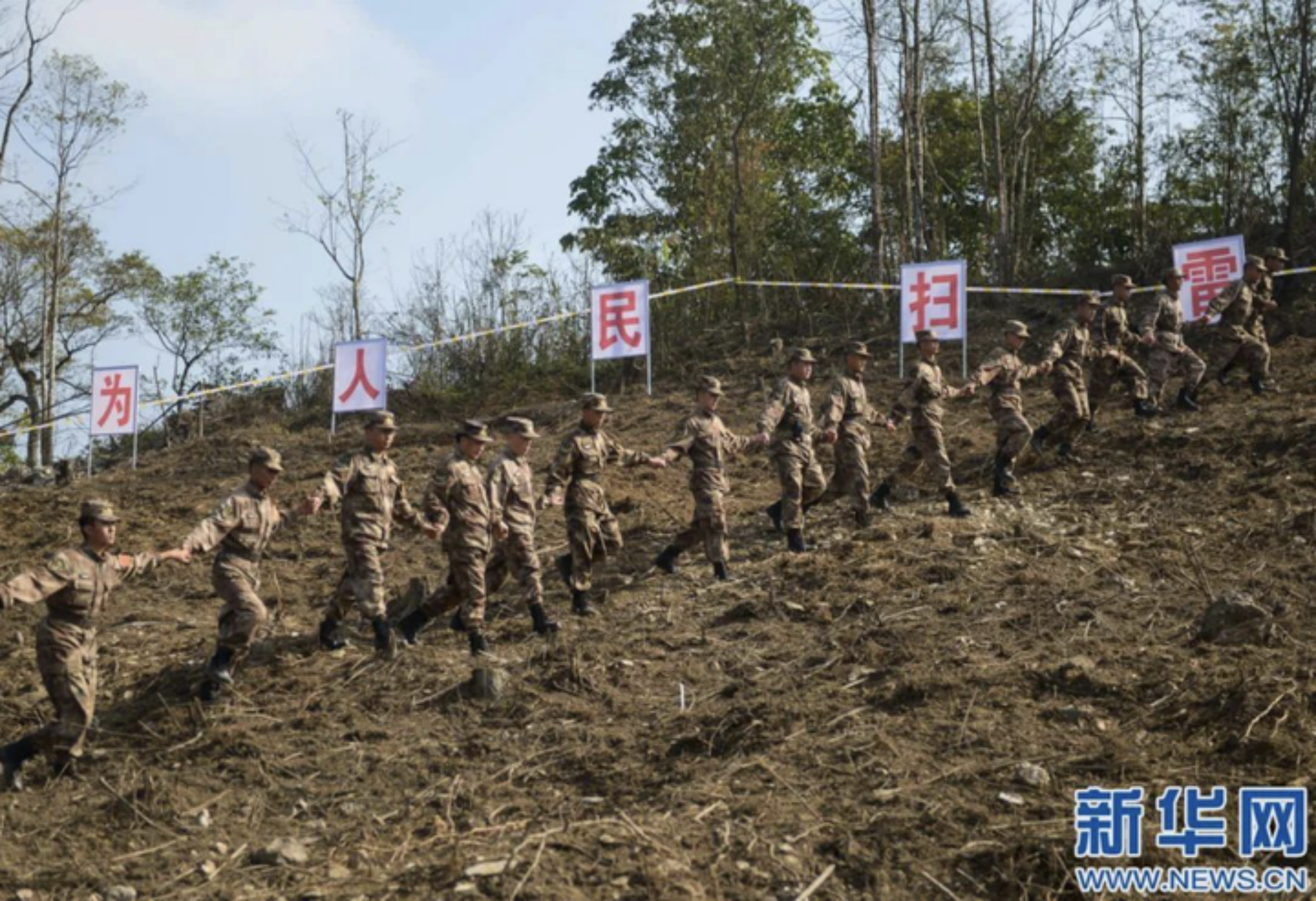 红河州中越边境,解放军扫雷部队手拉手走过扫雷区域后,向当地民众移交。 红河州中越边境,解放军扫雷部队手拉手走过扫雷区域后,向当地民众移交。