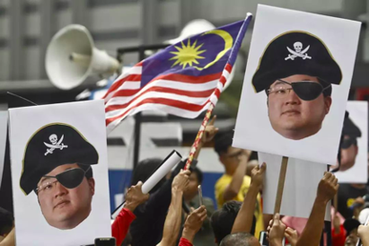 2018 年 7 月，吉隆坡，抗议者高举着刘特佐海盗形象的照片