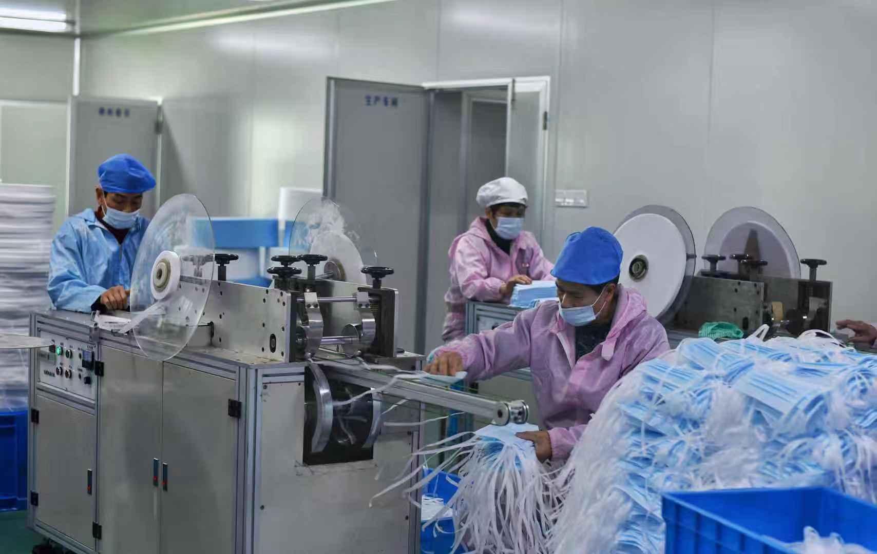 宁波奉化区一家医疗器械生产车间内工人们在生产一次性医用口罩