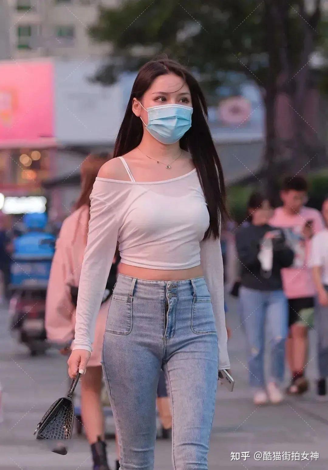 街拍女神白色露肩上衣修身牛仔裤的时尚女生
