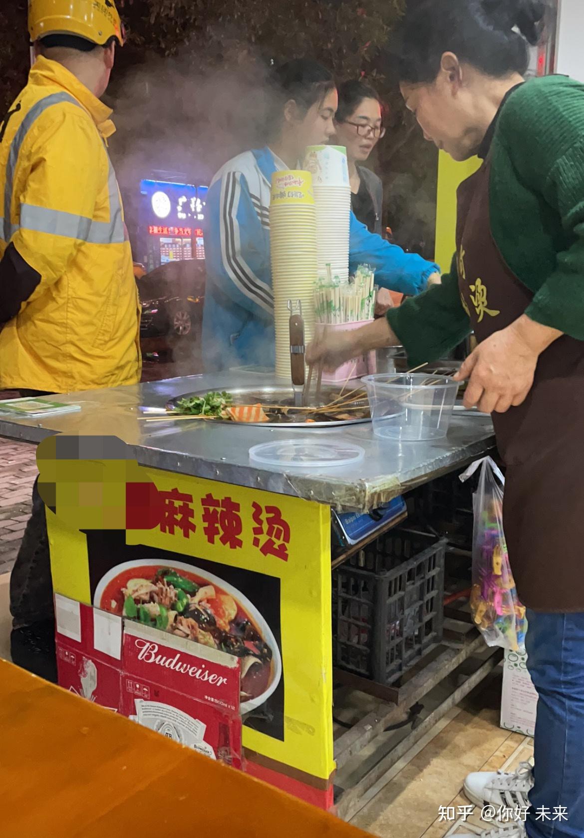 路上遇上热闹的麻辣烫摊子,一瓶啤酒,一碗杂烩,坐在店门口的凳子上