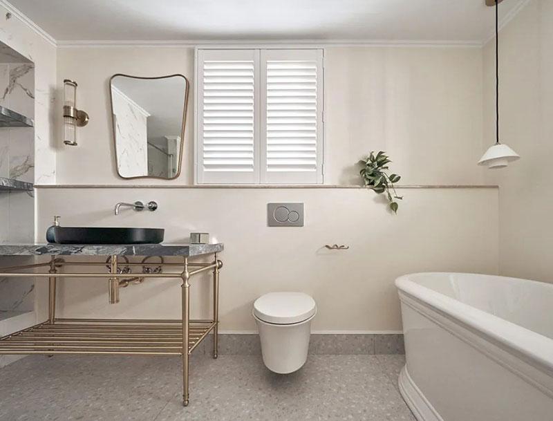 铜边镜面,木百叶窗,圆弧浴缸,与蓝色手工拼贴花砖,在墙面上涂刷一抹