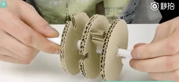 在纸板上用圆规画三个圆形,制作成齿轮,将锁芯和齿轮连接起来,用胶粘