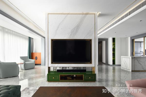 电视背景墙采用鱼肚白的大理石,透过吊顶灯带泛下的光晕,背景与空间融