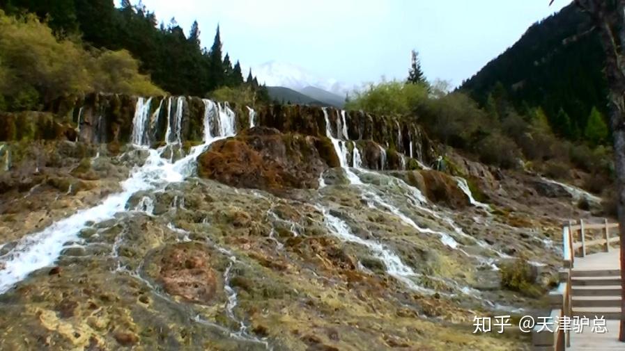 只见以金黄色为主的坡面上,辉映着薄薄的一层水波,这层流水因坡面钙华