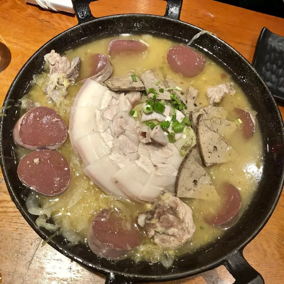 东北酸菜白肉火锅大部分用的是紫铜炭火锅,熬好的猪骨汤里放入切好的