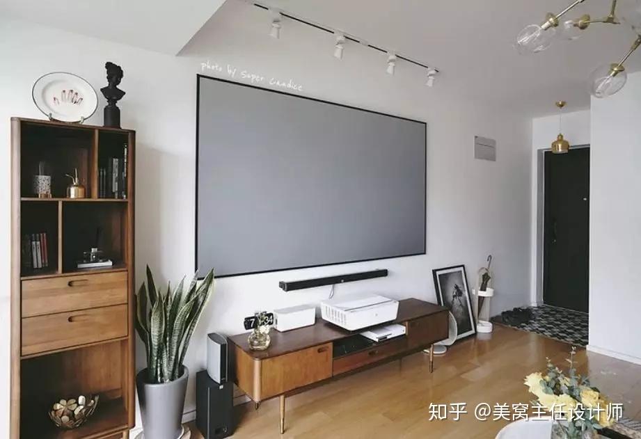投影仪固定在沙发上方,幕布部分用吊顶把轨杆隐藏起来,电视与投影互不