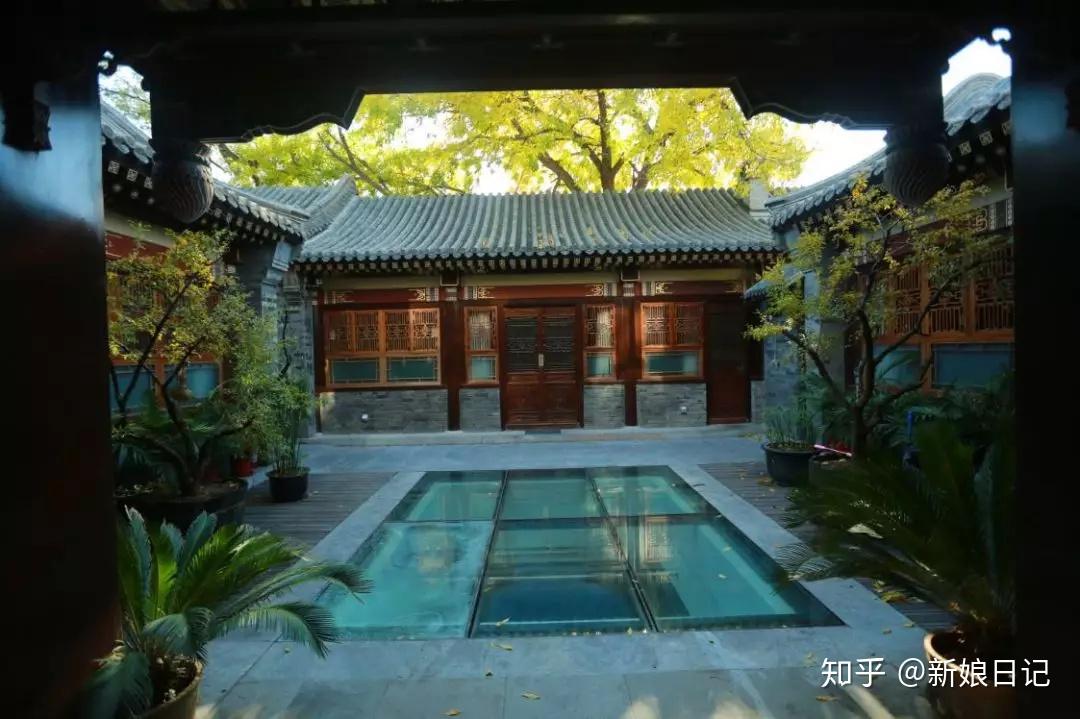 古老的屋瓴飞檐,灰色系的墙壁镶嵌着古铜色的门窗,绿植将整个院子点缀