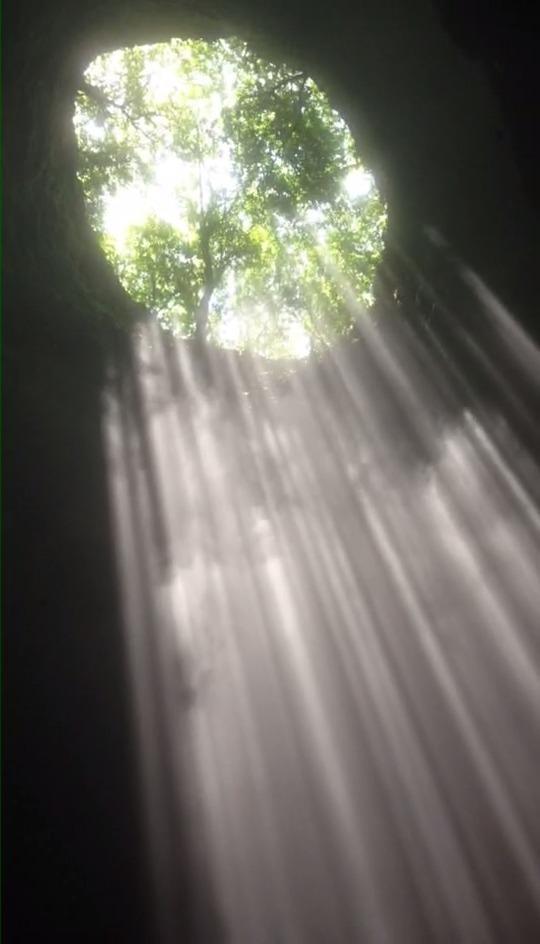 从头顶90度宣泄下来的阳光正好照进洞内,而且由于丁达尔现象的关系
