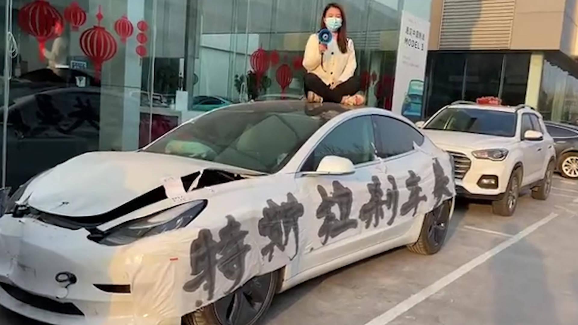 2021年上海车展第1天女车主站特斯拉车顶维权被拽下车发生了什么