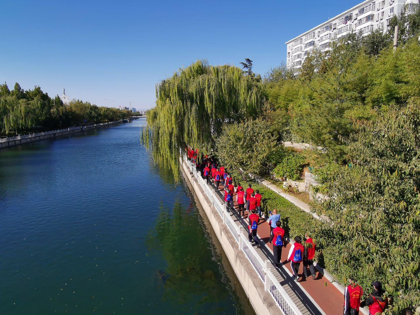 张楠,世界竞走冠军范晓玲共同击鼓发令,在碧波荡漾的护城河水映衬下